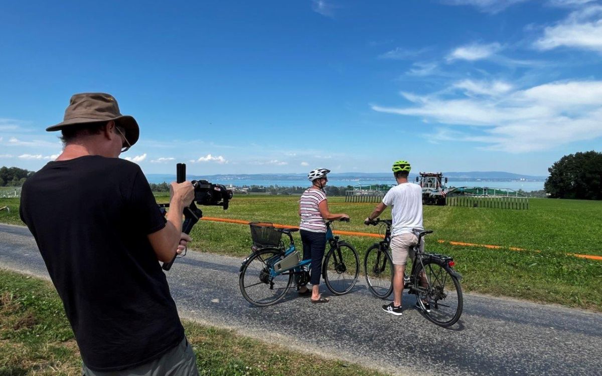 Zwei Velofahrer beobachten den Lohnunternehmer Ralf Hug beim Gülle ausbringen. Bild: kim